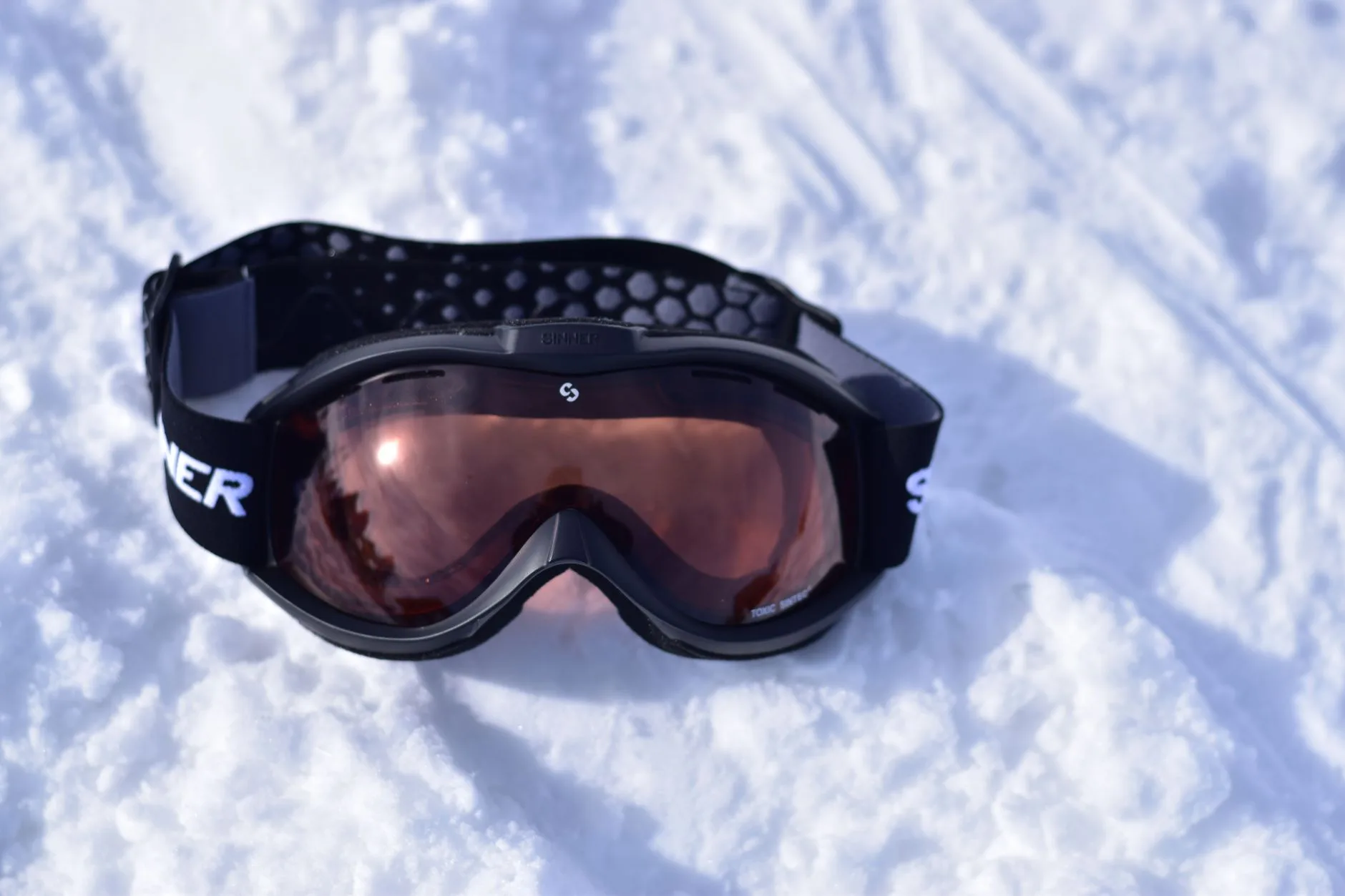 Getönte Schneebrille auf frischem Schnee im Wintersonnenlicht