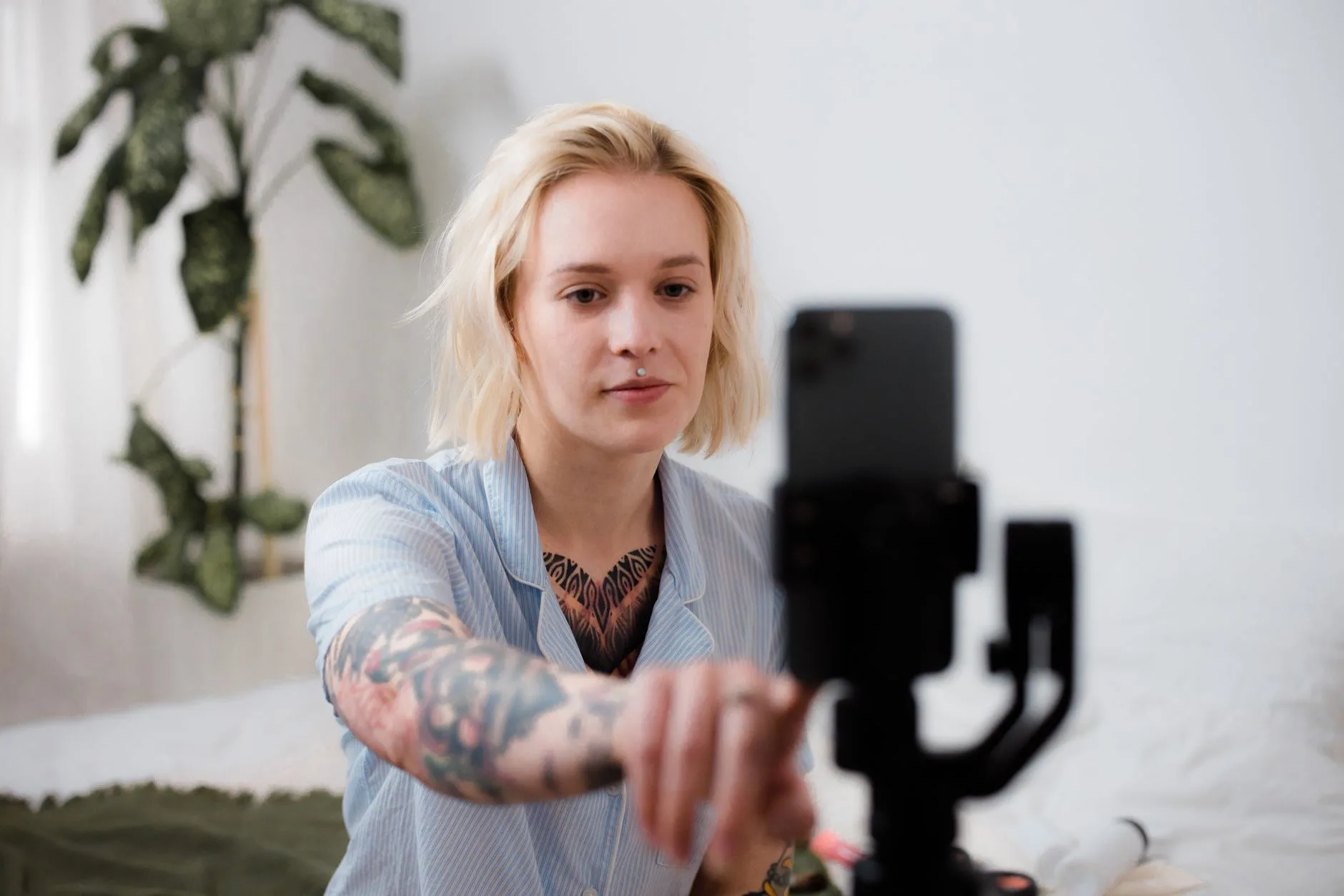 Person richtet ein Smartphone auf einem Stativ ein, um ein Video aufzunehmen